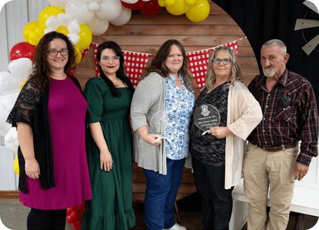 Group photo with Lucky Paws Doghouse Inc. team holding awards
